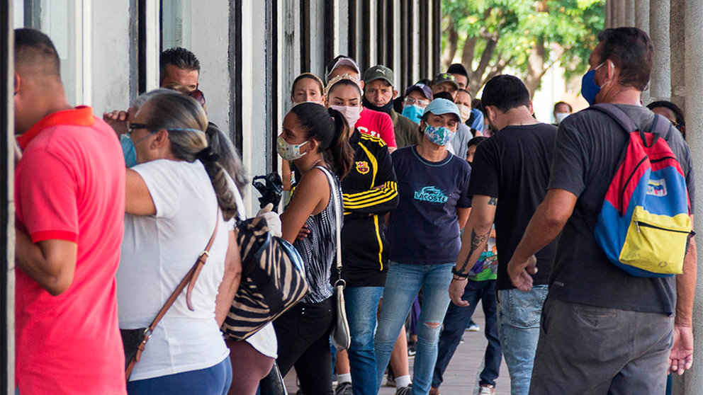 ACOMPAÑA CRÓNICA: CORONAVIRUS VENEZUELA - AME5847. MARACAIBO (VENEZUELA), 11/06/2020.- Fotografía del pasado 7 de junio que muestra a un grupo de personas en fila para entrar a un local comercial en Maracaibo (Venezuela). Como todos los males de Venezuela, el coronavirus se ha ensañado con Maracaibo, la otrora urbe pujante que lleva años castigada por la crisis y ahora está condenada a una cuarentena radical para intentar detener el contagio de una "cepa más peligrosa" que ha matado más rápido que en el resto del país. "Tenemos los (números) más altos de mortalidad", dijo en una declaración el gobernador del estado Zulia (oeste), el chavista Omar Prieto, al ofrecer un balance sobre la pandemia por COVID-19 en esa región que registra 183 contagiados y seis fallecidos, de un total de 23 que se computan en todo el país. EFE/ Henry Chirinos