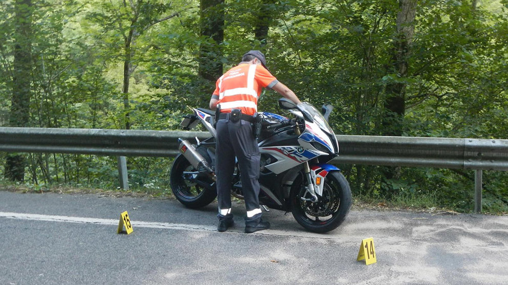 Un agente la Policía Foral recupera la moto tras el siniestro mortal ocurrido en Valcarlos. CEDIDA