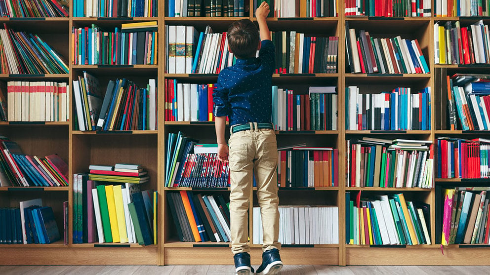 Un niño escogiendo un libro en una biblioteca. AYUNTAMIENTO DE PAMPLONA