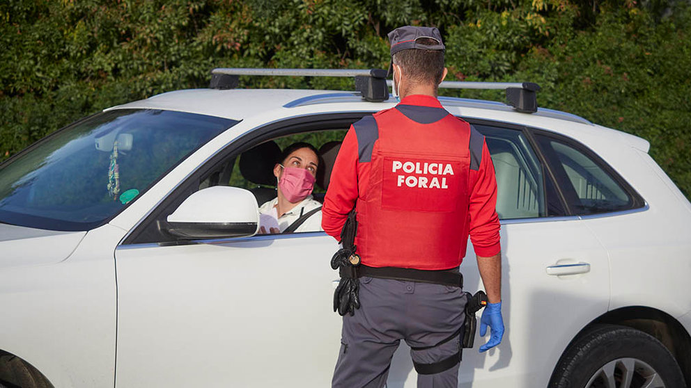 Un policía foral pide la documentación a un vehículo que circula por la carretera de entrada a la localidad de Peralta, Navarra (España) a 24 de septiembre de 2020. En este municipio navarro, a partir de hoy jueves 24, ha entrado en vigor la prohibición de entrar y salir salvo para desplazamientos imprescindibles, como medida para contener el incremento de casos de Covid-19, que se sitúan en una tasa de 1.700 casos por 100.000 habitantes.
24 SEPTIEMBRE 2020;COVID;PERALTA;CORONAVIRUS;NAVARRA;
Eduardo Sanz / Europa Press
24/9/2020
