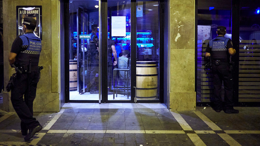 Dos policías municipales controlan un bar de la parte vieja de Pamplona. PABLO LASAOSA
