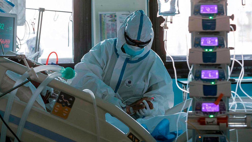 Una enfermera de un centro hospitalario atiende a un paciente ingresado por COVID-19 en la UCI. EFE/Marcial Guillén