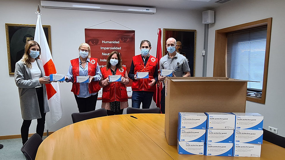 Dos trabajadores de Irumold entregan las mascarillas en la sede de Cruz Roja Navarra. CEDIDA