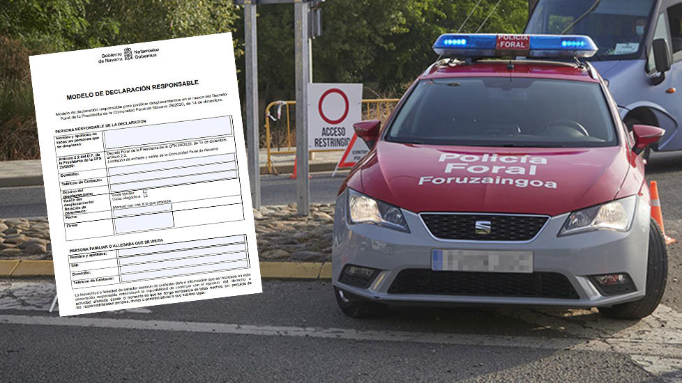 Un coche de policía foral vigila la carretera junto al documento de "Declaración Responsable que hay que cumplimentar para entrar o salir de Navarra" en Navidad.