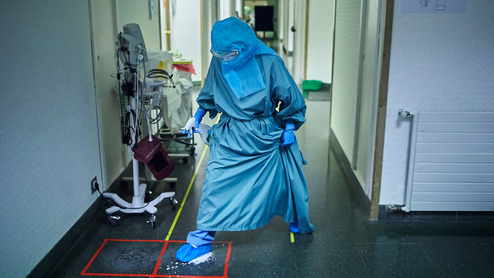 Una enfermera desinfecta sus calzas en la 'planta Covid' de la CUN. PABLO LASAOSA