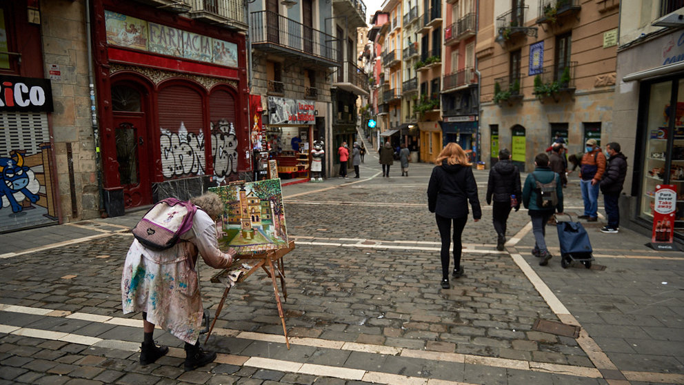 Un hombre pinta en mitad de la calle Mercaderes de Pamplona durante la pandemia de coronavirus. MIGUEL OSÉS