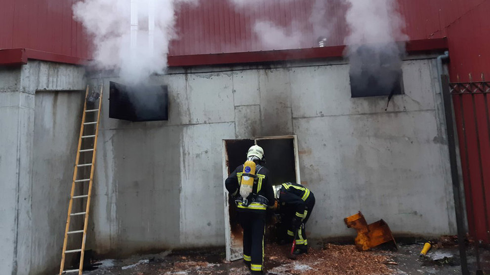 Dos bomberos trabajan en la extinción de un incendio en el polideportivo de Bera. BOMBEROS DE NAVARRA