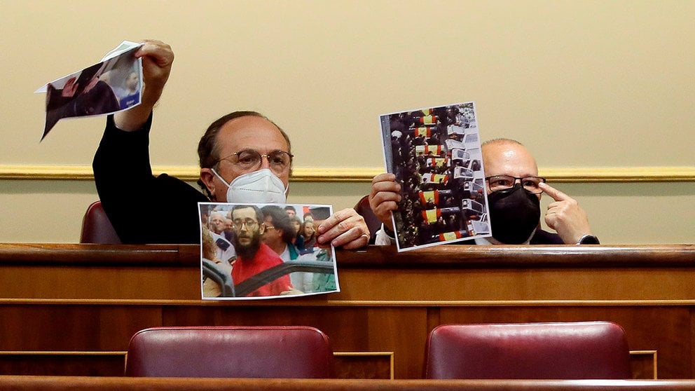 Los diputados de Vox Francisco José Alcaraz (d) e Ignacio Gil Lázaro muestran retratos de víctimas del terrorismo desde sus escaños durante en el pleno en el Congreso de los Diputados. EFE/Mariscal