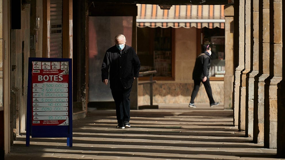 Una persona camina por Pamplona con mascarilla para evitar propagar el coronavirus. PABLO LASAOSA