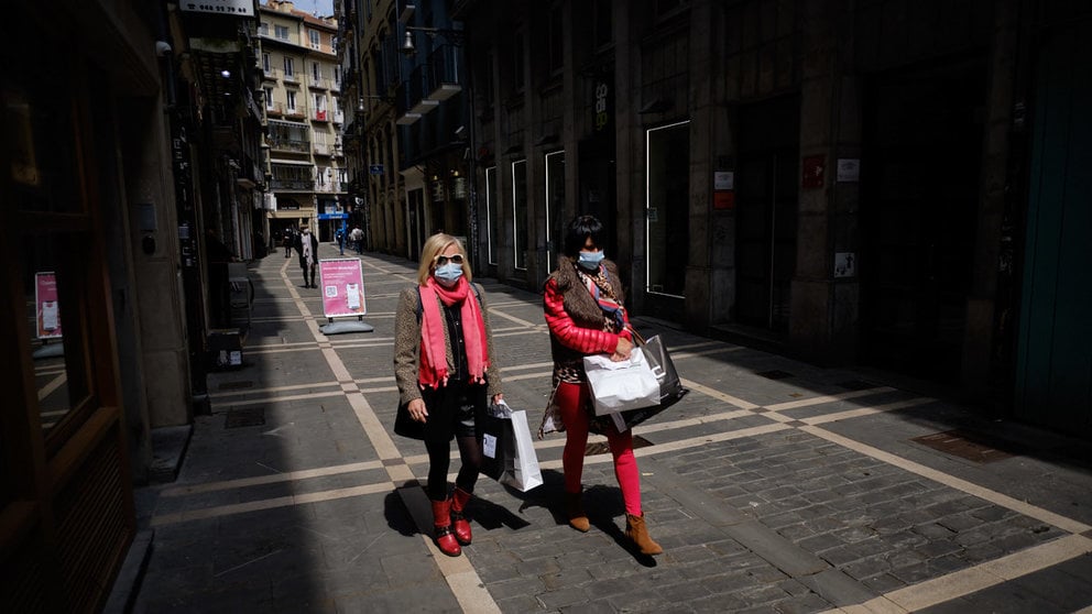 Varias personas pasean con mascarillas por las calles de Pamplona y sus comercios durante la pandemia del coronavirus. MIGUEL OSÉS