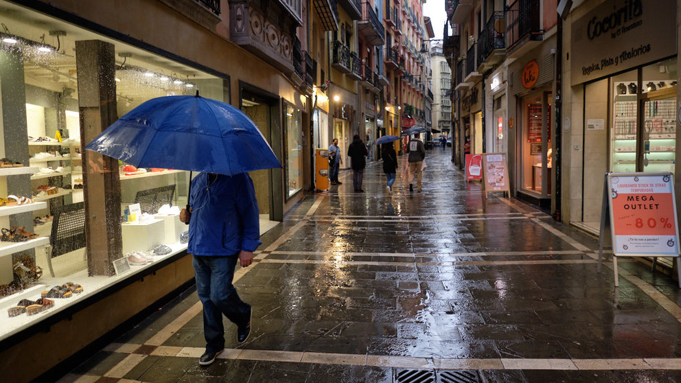 Un hombre con paraguas camina por las calles de Pamplona durante una tormenta de la primavera de 2021. MIGUEL OSÉS