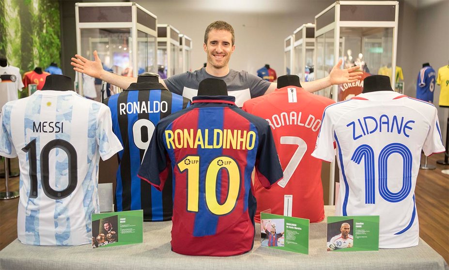 Carlos Catalán posa con algunas de las camisetas de fútbol de su colección que se exhiben en el Centro Comercial Itaroa.