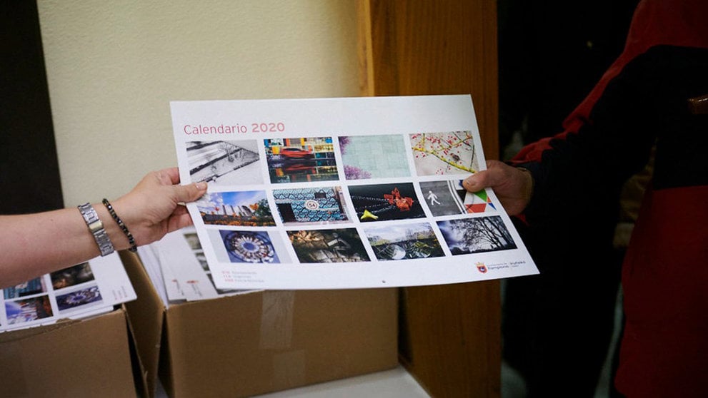 Una voluntaria de ASVONA entrega en calendario municipal a una persona en una edición anterior. PABLO LASAOSA