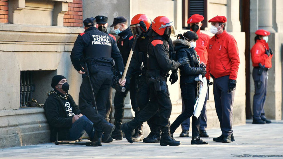 Varios manifestantes se encadenan en la fachada del Parlamento de Navarra. PABLO LASAOSA