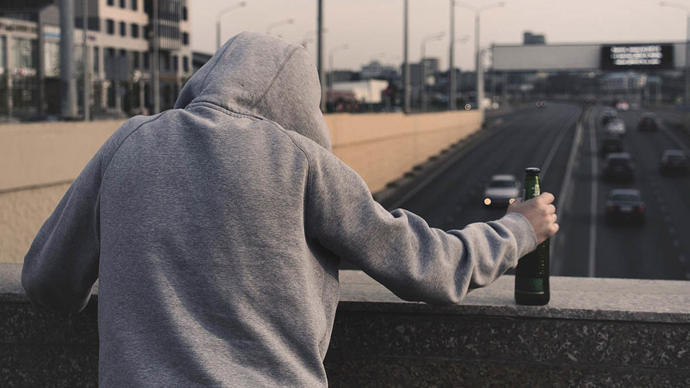 Un joven sujeta una botella sobre una autopista. ARCHIVO