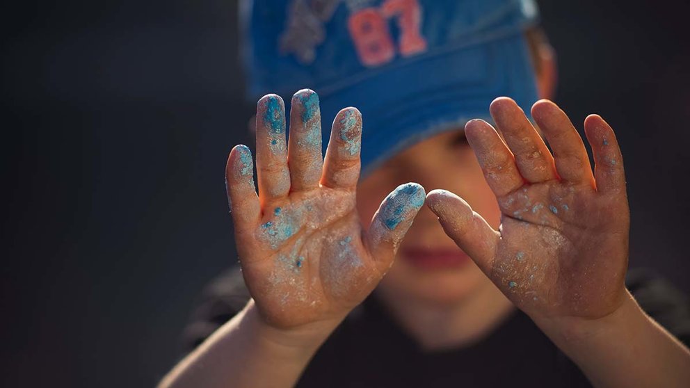 Un niño enseña sus manos manchadas de pintura. ARCHIVO