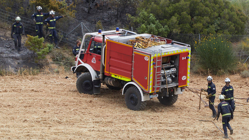 Un retén de bomberos trabajan en la extinción y control del incendio de la sierra del Perdón. IÑIGO ALZUGARAY