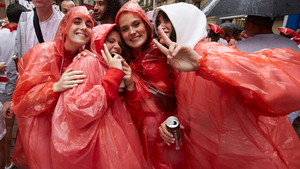 Ambiente por las calles de Pamplona en los momentos posteriores al Chupinazo con el que se ha dado inicio a los Sanfermines 2022, este año con la lluvia como portagonista. IÑIGO ALZUGARAY