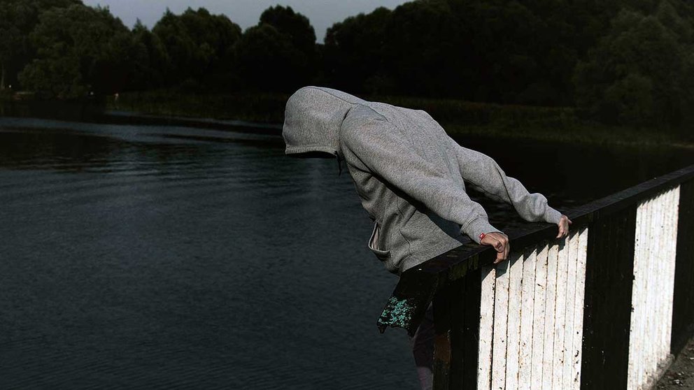 Un joven sopesa lanzarse desde lo alto de un puente. PIXABAI