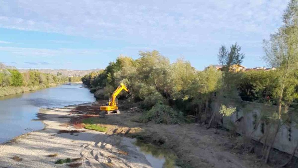 Una grúa trabaja en la limpieza de la vegetación a orillas del río Arga a su paso por Funes. CEDIDA