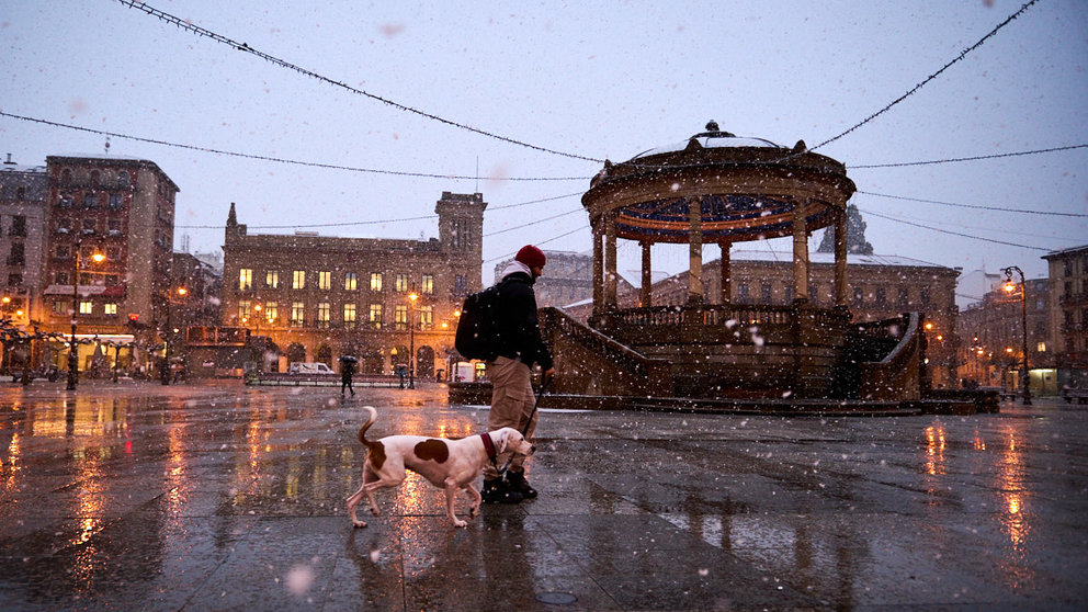 La Plaza del Castillo de Pamplona anochece este miércoles bajo copos de nieve durante el temportal que azota la Comunidad Foral. PABLO LASAOSA