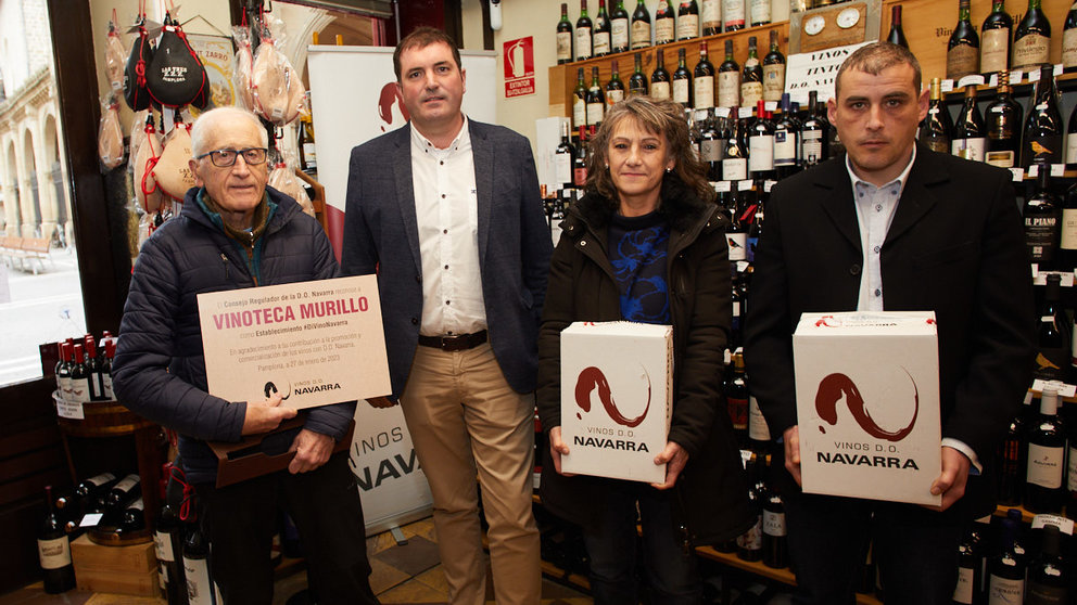 El presidente del Consejo Regulador de la D.O. Navarra, David Palacios, entrega el premio a las personas afortunadas que han ganado un año de vino gratis en la Vinoteca Murillo de Pamplona. IÑIGO ALZUGARAY