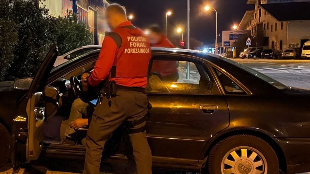 El agente evita que el conductor arranque el coche antes de proceder a su detención en las inmediaciones de un club nocturno en Noáin. POLICÍA FORAL