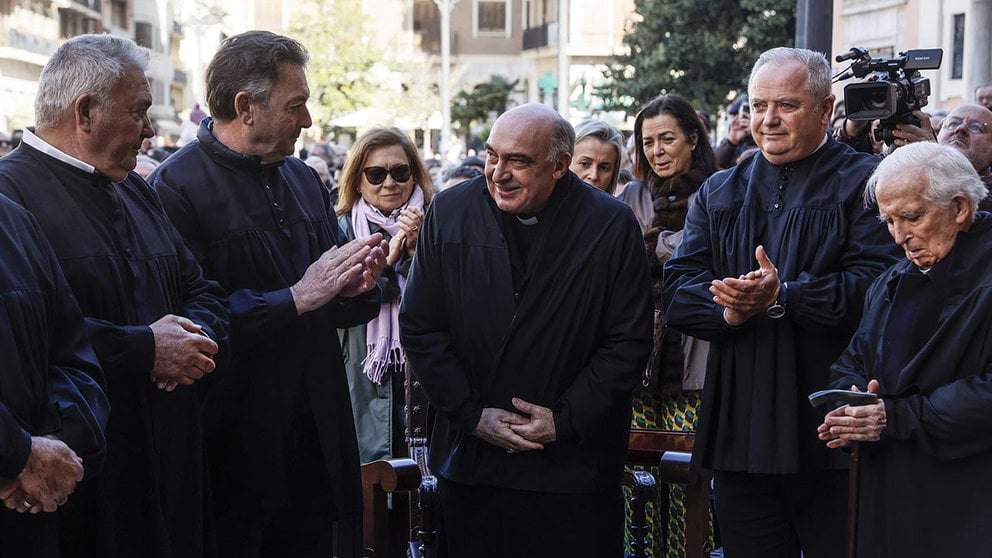 El arzobispo de Valencia, Enrique Benavent (c), recibe el blusón de honor durante la presentación de la Virgen de los Desamparados en una sesión judicial del Tribunal de Aguas. ROBER SOLSONA / EUROPA PRESS
