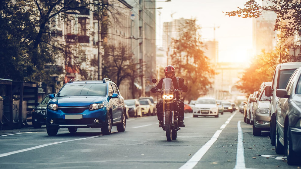 Una moto circulando por las calles de una ciudad. AdobeStock