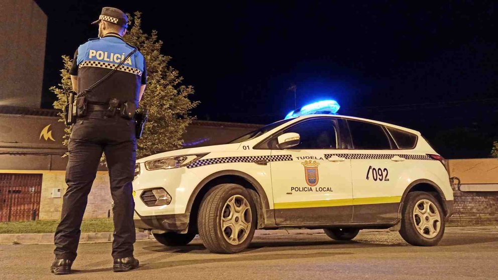 Un agente de la Policía Local de Tudela ante un coche patrulla. POLICÍA LOCAL DE TUDELA
