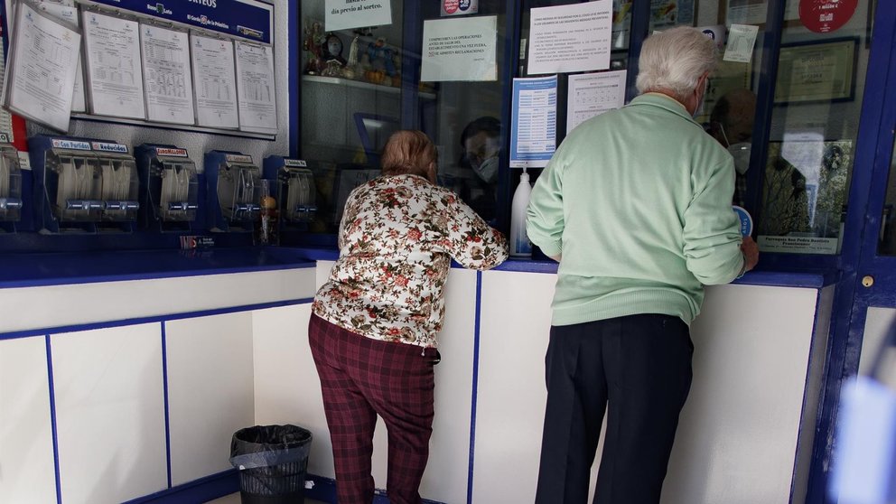 Un hombre y una mujer compran lotería en una Administración - Eduardo Parra - Europa Press - Archivo