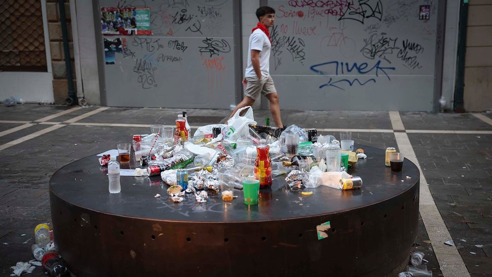 GRAFCAV630. PAMPLONA, 08/07/2023.- Los más trasnochadores deambulan por las calles del casco histórico de Pamplona entre la basura acumulada tras la primera noche del fin de semana de los Sanfermines 2022 antes del encierro de este sábado. EFE/ Villar López
