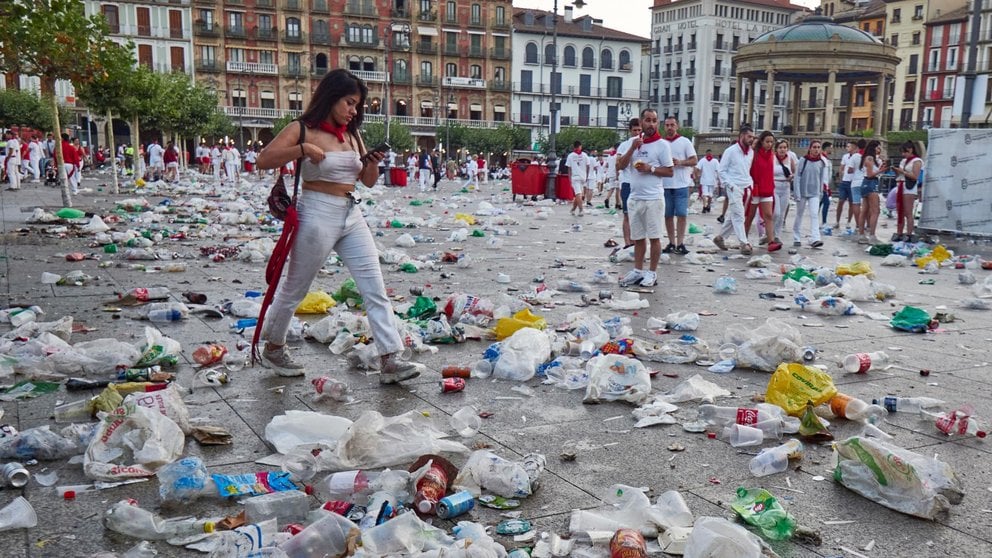 Una mujer camina entre la basura durante el fin de semana de las fiestas de San Fermín 2023. EDUARDO SANZ