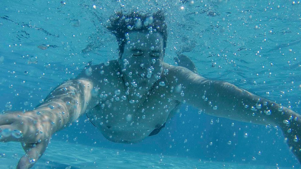 Un joven se sumerge en el agua de la piscina municipal de Oira, este miércoles en Ourense, donde se ha registrado la temperatura máxima de lo que va de jornada en Galicia con 41,7 grados sobre las tres de la tarde. EFE/Brais Lorenzo