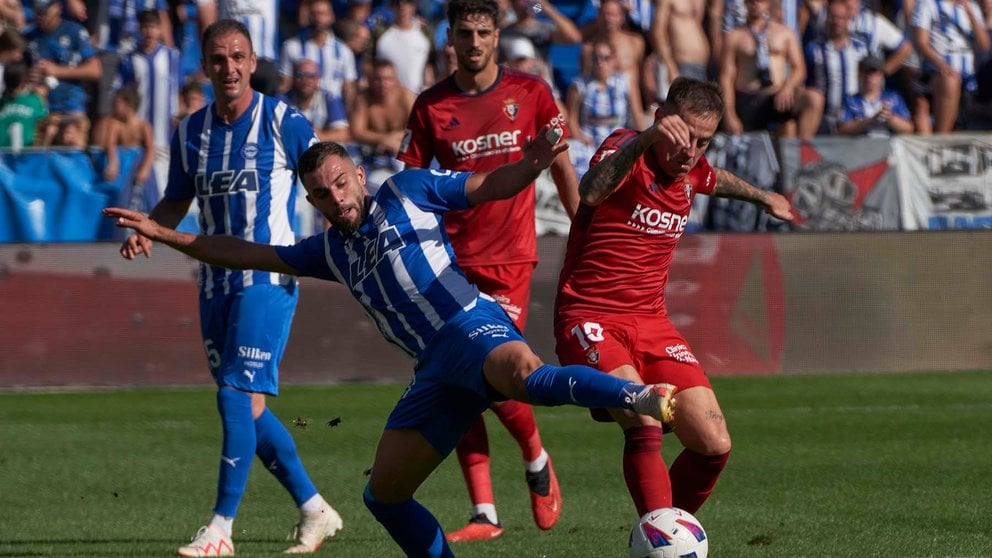 El centrocampista del Osasuna Aimar Oroz (d) lucha por el balón con el defensa serbio del Deportivo Alavés Aleksander Sedlar en el partido de LaLiga jugado este domingo en el estadio de Mendizorrotza de Viotria-Gasteiz. EFE/ ADRIÁN RUIZ HIERRO