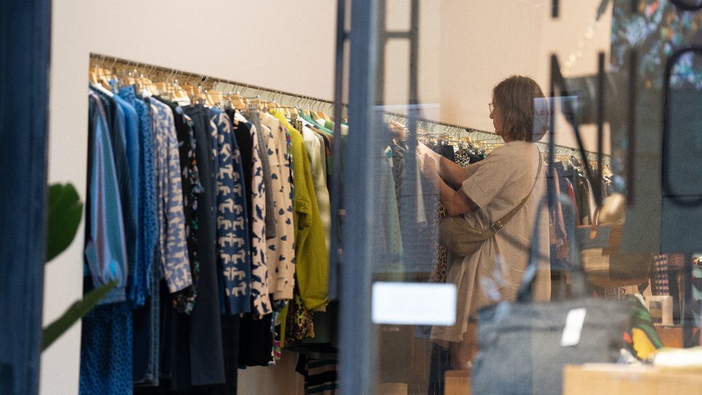 Una mujer busca ropa en una tienda de moda de comercio local. DAVID ZORRAKINO / EUROPA PRESS