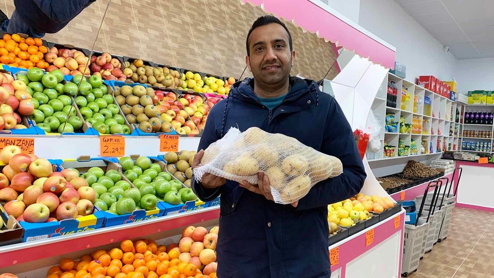 Imran Aziz sostiene una bolsa de patatas en su tienda de fruta en Pamplona. Navarra.com