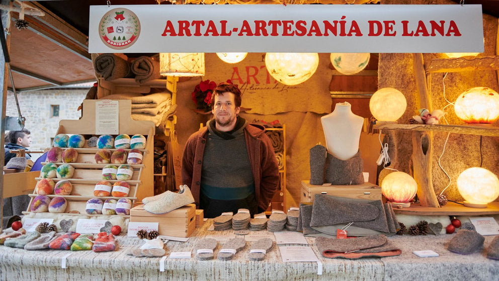 Alain Flores atiende en el puesto de Artal, un negocio de artesanía dedicado a la elaboración de productos hechos con lana. IRANZU LARRASOAÑA
