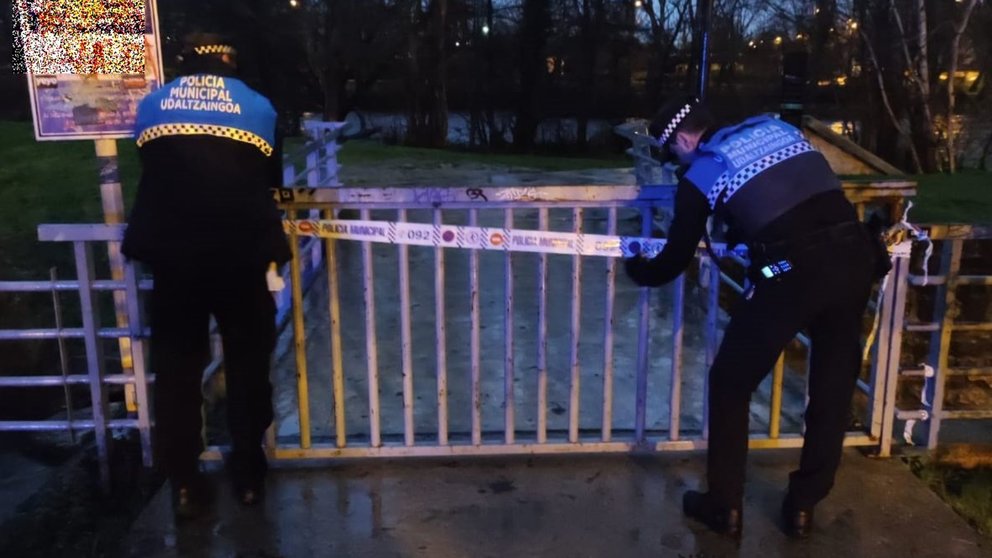 Agentes de la Policía Municipal de Pamplona cortan el acceso a las pasarelas del río Arga por las fuertes lluvias. POLICÍA MUNICIPAL DE PAMPLONA