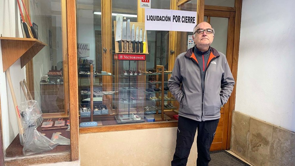 Jesús María Gil en la fachada de su tienda donde anuncia la liquidación por cierre. Navarra.com