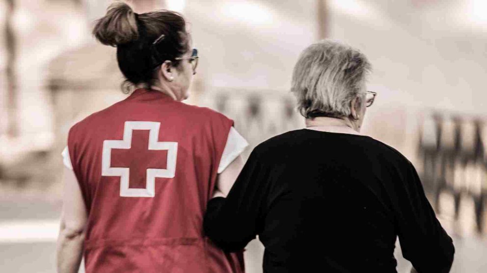 Una voluntaria de Cruz Roja cuida de una anciana en Pamplona. CRUZ ROJA