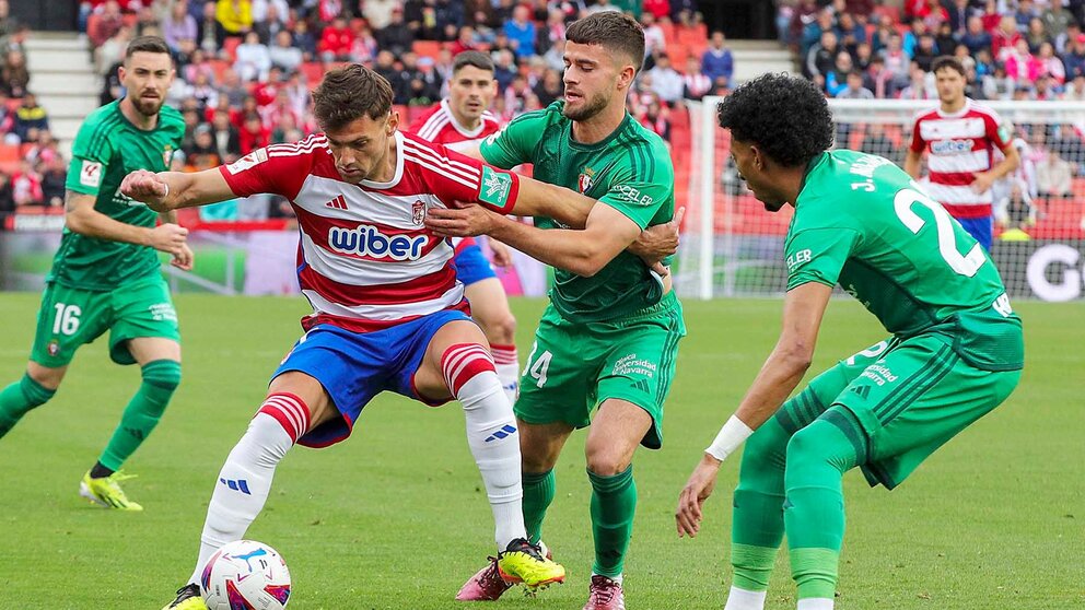 El delantero argentino del Granada Lucas Boyé y el centrocampista de Osasuna Iker Muñoz, durante el partido de la jornada 33 de LaLiga EA Sports que enfrenta al Granada CF con el Osasuna en el Nuevo estadio Los Cármenes de Granada.- EFE/ Pepe Torres