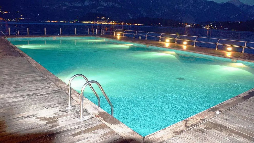 Una piscina iluminada por la noche. PIXABAI