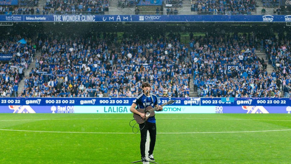 Javi Robles con la camiseta del Oviedo en el terreno de juego del Carlos Tartiere interpretando su canción antes de un partido.  CEDIDA