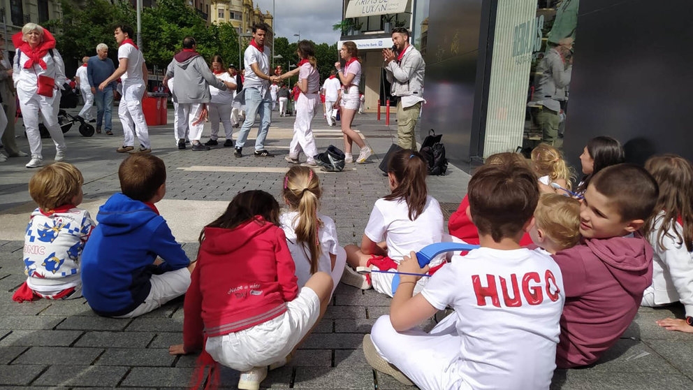 Un grupo de niños pequeños observando a Al López cantar. NAVARRA.COM