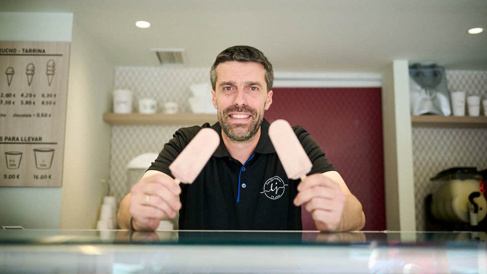 Mikel Falces con los polos de kalimotxo que ha sacado a la venta en la heladería Jijonencos para San Fermín 2024. PABLO LASAOSA