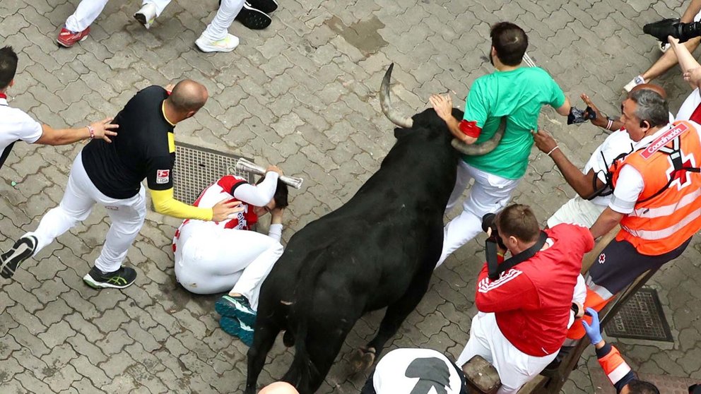 Momento en el que un toro de Victoriano del Río casi cornea a un mozo en el tercer encierro de San Fermín 2024 con toros de Victoriano del Río. ÍÑIGO ALZUGARAY