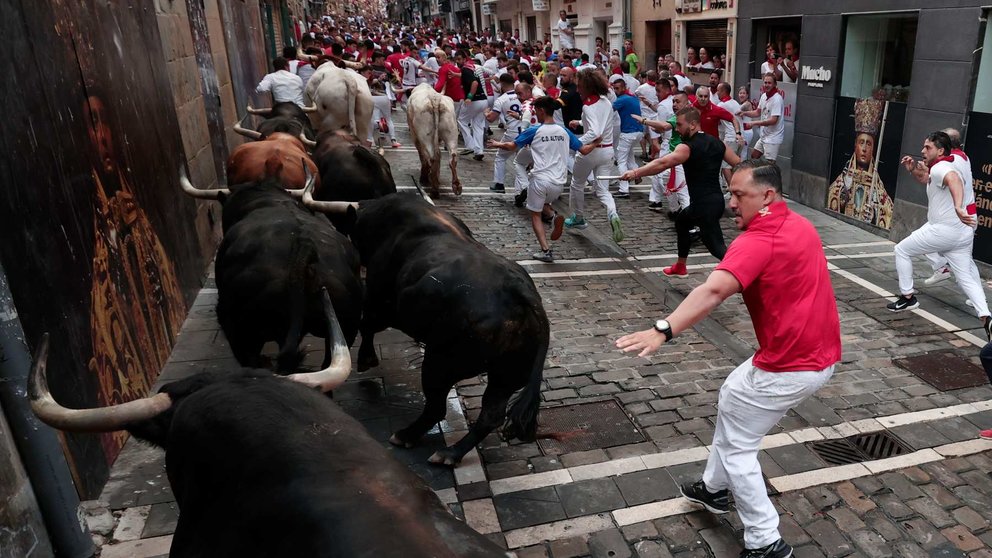 Los toros de la ganadería de Fuente Ymbro pasan por la curva de Mercaderes y enfilan la calle de la Estafeta en el cuarto encierro de los Sanfermines este miércoles, en Pamplona. EFEJesús Diges