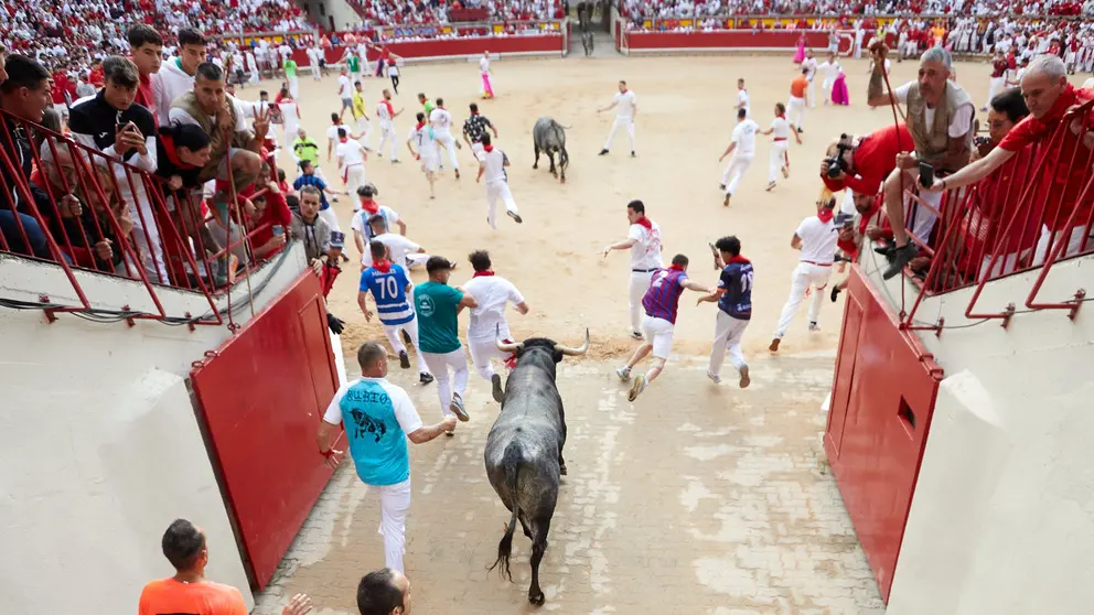 Octavo y último encierro de las fiestas de San Fermín 2024 con toros de Miura en el tramo del callejón y la entrada a la Plaza de Toros. IÑIGO ALZUGARAY