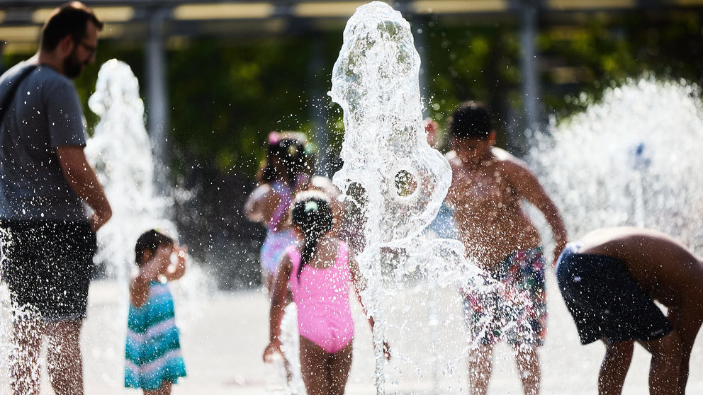 Unos niños juegan en la Fuente de los Chorros en el parque de Yamaguchi de Pamplona en el primer día de una nueva ola de calor de este verano. IÑIGO ALZUGARAY